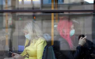 epa08727233 Women wearing protective face masks sit in a trolleybus in Riga, Latvia, Latvia, 07 October Face masks use is mandatory in public transport from 07 October in Latvia.  EPA/TOMS KALNINS