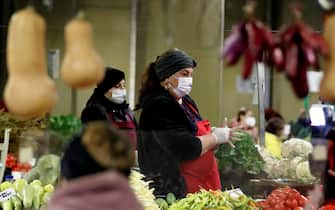epa09526757 A Romanian farmer woman that wears a protective mask adjusts the protective gloves while waiting for customers on her stand at a neighborhood market in Bucharest, Romania, 16 October 2021. Romanian health authorities are overwhelmed by the outbreak of the fourth wave, as the number of infected people with SARS-CoV-2 are rising from one day to another. Metropolitan police and gendarmerie were checking how the market customers and vendors comply to the sanitary rules.  EPA/ROBERT GHEMENT