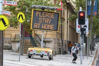 SYDNEY, AUSTRALIA - APRIL 10: A digital sign warning people to stay at home, wash their hands and remain apart from the person next to them in North Sydney's CBD on April 10, 2020 in Sydney, Australia. Australians have been urged to avoid all unnecessary travel over the Easter long weekend as the nation continues to deal with the COVID-19 pandemic. The Federal Government has closed all non-essential business and implemented strict social distancing rules, while public gatherings are now limited to two people. New South Wales and Victoria have also enacted additional lockdown measures to allow police the power to fine people who breach the two-person outdoor gathering limit or leave their homes without a reasonable excuse. Queensland, Western Australia, South Australia, Tasmania and the Northern Territory have all closed their borders to non-essential travellers and international arrivals into Australia are being sent to mandatory quarantine in hotels for 14 days. (Photo by James D. Morgan/Getty Images)