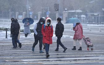 BEIJING, CHINA - NOVEMBER 7, 2021 - People walk in the snow on November 7, 2021 in Beijing, China. Beijing has seen its first snowstorm of 2021. (Photo credit should read An Xin / Costfoto/Barcroft Media via Getty Images)