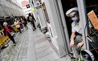 epa08456118 Tourists pass by a baker wax figure wearing face mask in Dresden, Germany, 31 May 2020. Tourism in Dresden restarts as Germany eases the lockdown to prevent the spread of the SARS-CoV-2 coronavirus causing the Covid-19 disease.  EPA/FILIP SINGER