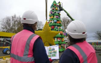 A model maker puts the finishing touches to a 33-foot tall LEGO Christmas tree, made with 364,481 DUPLO and LEGO bricks, at the LEGOLAND Windsor Resort in Berkshire.  Picture date: Wednesday November 10, 2021.