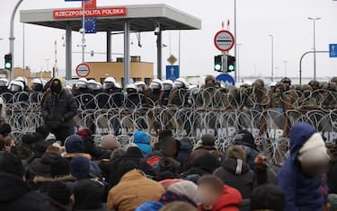 epaselect epa09583231 A handout photo made available by Belta news agency shows asylum-seekers, refugees and migrants gathering at the Bruzgi-Kuznica Bialostocka border crossing, Belarus, 15 November 2021. Asylum-seekers, refugees and migrants, who arrived at the Belarus-Poland border checkpoint of Bruzgi-Kuznica Bialostocka, reportedly broke through part of the barriers set up by Poland. Migrants from the Middle East began to leave the spontaneous camp set up near the border. It was noted that a large convoy of migrants, accompanied by Belarusian security officials, went out towards the frontier checkpoint Bruzgi. Since 08 November, several thousand migrants have been trying to enter the EU and have set up camp in a forest belt adjacent to the border.  EPA/OKSANA MANCHUK/BELTA HANDOUT HANDOUT EDITORIAL USE ONLY/NO SALES HANDOUT EDITORIAL USE ONLY/NO SALES