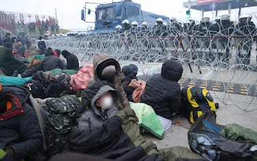 A handout photo made available by Belta news agency shows Polish servicemen guard the border in front of asylum-seekers, refugees and migrants who gathered at the Bruzgi-Kuznica Bialostocka border crossing, Belarus, 15 November 2021. Asylum-seekers, refugees and migrants, from the Middle East who began to leave the spontaneous camp set up near the border,  arrived at the Belarusian-Polish checkpoint of Bruzgi-Kuznica Bialostocka. It was noted that a large convoy of migrants, accompanied by Belarusian security officials, went out towards the frontier checkpoint Bruzgi. Since 08 November, several thousand migrants have been trying to enter the EU and have set up camp in a forest belt adjacent to the border. ANSA/OKSANA MANCHUK / BELTA / HANDOUT  HANDOUT EDITORIAL USE ONLY/NO SALES