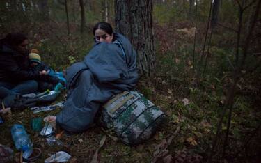 Illegal immigrant sits in sleeping bag after crossing polish belarusian border near Michalowo on October 6, 2021. (Photo by Maciej Luczniewski/NurPhoto via Getty Images)