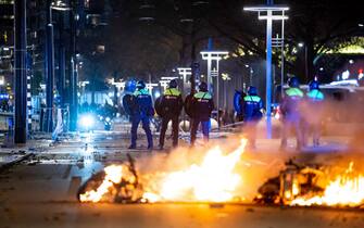 NETHERLANDS PROTEST RIOTS epa09593019 Policemen stand near burning objects after a protest against the '2G policy' turned into riots, with protesters setting fires in the street and destroying police cars and street furniture, Rotterdam, Netherlands, 19 November 2021. Hundreds of demonstrators gathered on Coolsingel earlier that evening because they disagree with the 2G policy, which refers to the two Dutch words for vaccinated and recovered. EPA/VLN NIEUWS