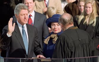 WASHINGTON, :  US President William Jefferson Clinton in a picture taken 20 January 1993 in Washington, DC, takes the oath of office from Chief Justice of the Supreme Court William Rehnquist to become the 42nd President of the US as his wife Hillary Rodham Clinton looks on. (Photo credit should read TIM CLARY/AFP via Getty Images)