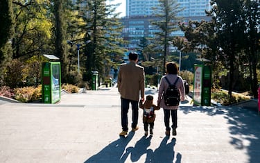 CHINA - 2016/10/23: A couple of young parents take their only kid's hand walking on the road.  China has one of the worlds lowest total fertility rates.  According to the 2016 China Statistical Yearbook, the countrys 2015 fertility rate was about 1.05  far below the 2.1 rate needed to keep the population level steady.  Chinese demography experts call on the central government to further loosen its birth control policy within two years owing to a predicted population decline in 2018. (Photo by Zhang Peng/LightRocket via Getty Images)