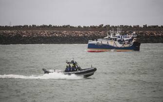 epa09604968 French Gendarmes Patrol near a French fishing boat blocking the entrance of the Port of Calais starting a day of protests to mark anger over the issue of post-Brexit fishing licences, in Calais, France, 26 November 2021.  EPA/MOHAMMED BADRA