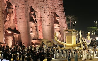 epa09603506 Actors carry a golden boat as they parade during the opening ceremony of the Avenue of Sphinxes at the ancient Temple of Luxor, in Luxor, Egypt, 25 November 2021. The 3,000-year-old ancient promenade Avenue of Sphinxes (El Kebbash Road) was opened to the public after years of restauration with a grand ceremony.  EPA / KHALED ELFIQI
