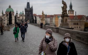 epaselect epa09600298 Tourists wearing protective face masks walk on the Charles Bridge in Prague, Czech Republic, 24 November 2021. Tests in the Czech Republic confirmed almost 26.000 new cases of Covid-19 on 23 November, the highest single-day number since the outbreak began, according to data from the Czech Ministry of Health.  EPA/MARTIN DIVISEK