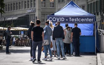 People queue at a Covid test center installed in a street of Swiss capital Bern on September 17, 2021. - People who have not been vaccinated and have not recovered from the coronavirus will have to present a negative Covid test to enter Switzerland from September 20, 2021. The Swiss government wants to avoid an increase of cases after the autumn holidays, it said. (Photo by Fabrice COFFRINI / AFP) (Photo by FABRICE COFFRINI/AFP via Getty Images)