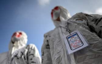 TOPSHOT - Protesters wear masks and full protection suits as they demonstrate in Geneva on October 9, 2021, during a rally against coronavirus measures, Covid-19 health pass and vaccination. - On 28 November 2021, Swiss voters will be asked whether they accept laws passed by the government on 19 March 2021 that paved the way for the introduction of Switzerlands Covid certificate, a system that provides proof of vaccination, recovery or a negative test. (Photo by Fabrice COFFRINI / AFP) (Photo by FABRICE COFFRINI/AFP via Getty Images)