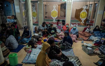 Evacuees take shelter at the local mosque of Sumber Wuluh village, in Lumajang, on December 5, 2021, after the eruption of Semeru volcano. (Photo by JUNI KRISWANTO / AFP) (Photo by JUNI KRISWANTO/AFP via Getty Images)