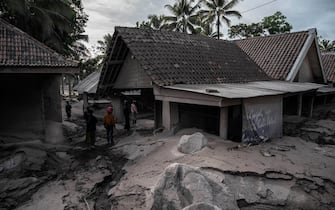 Houses are seen covered in volcanic ash at Sumber Wuluh village in Lumajang on December 5, 2021, after the Semeru volcano eruption that killed at least 13 people. (Photo by JUNI KRISWANTO / AFP) (Photo by JUNI KRISWANTO/AFP via Getty Images)
