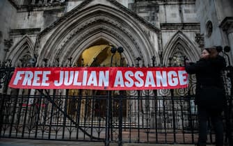 LONDON, ENGLAND - DECEMBER 10: A supporter of Julian Assange hangs a banner outside the Royal Courts of Justice on December 10, 2021 in London, England.  The United States had appealed the January ruling of a district court judge who said Mr Assange could not be extradited to the US, where he is charged with hacking and other crimes, due to his mental state.  The Wikileaks founder has been imprisoned since 2019, following seven years living in the Ecuadorian embassy in London, where he was avoiding extradition to Sweden on unrelated charges.  (Photo by Chris J Ratcliffe / Getty Images)