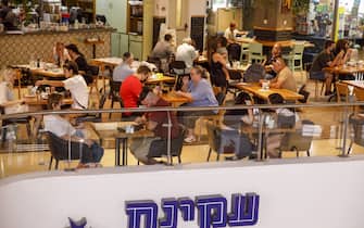 Customers at a coffee shop inside the Dizingoff Center shopping mall in Tel Aviv, Israel, on Monday, Sept. 20, 2021. A third dose of the Pfizer Inc.-BioNTech SE Covid vaccine can dramatically reduce rates of Covid-related illness in people 60 and older, according to data from a short-term study in Israel. Photographer: Kobi Wolf/Bloomberg