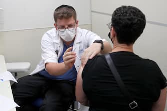 epa09421723 A nurse injects an Israeli man with a third shot of COVID-19 vaccine in Jerusalem, 20 August 2021. Israel has started to offer a third shot of covid vaccine to people aged over 40 as a measure to stop the spreading of the Delta variant.  EPA/ATEF SAFADI