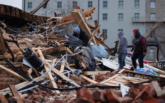 MAYFIELD, KY - DECEMBER 11:  People search through a tornado damaged building on December 11, 2021 in Mayfield, Kentucky. Multiple tornadoes tore through parts of the lower Midwest late on Friday night leaving a large path of destruction. (Photo by Brett Carlsen/Getty Images)