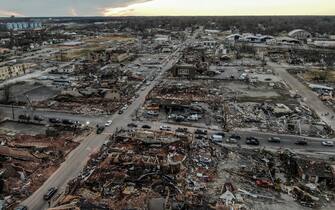 epa09637522 An aerial photo made with a drone shows widespread destruction of homes and businesses after tornadoes moved through the area leaving destruction and death across six states, in Mayfield, Kentucky, USA, 11 December 2021. According to early reports as many as 75 to 100 people lost their lives in Kentucky with more dead in Arkansas in the storms on 10 December.  EPA/TANNEN MAURY