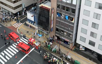 Firefighters outside the building where the fire occurred in Osaka
