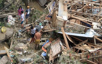 Residents salvage belongings from their destroyed houses at Talisay in Cebu province on December 17, 2021, a day after Super Typhoon Rai hit.  (Photo by Alan TANGCAWAN / AFP) (Photo by ALAN TANGCAWAN / AFP via Getty Images)