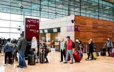 epa09098362 Passengers wait in line to check-in for their flight at Terminal 1 of the Berlin Brandenburg Airport, in Schoenefeld, Germany, 26 March 2021. German tourist are set to travel to the Spanish island of Mallorca over the Easter holiday season after popular tourist destination was taken off Germany s list of coronavirus 'risk areas.'  EPA/FILIP SINGER