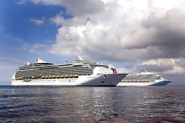 Cruise ship anchored off the shore of Grand Cayman Island, Royal Caribbean Caribbean cruise liner, Mariner of the Sea and Carnival Cruise Liner, turning to return to sea. (Photo by: MyLoupe/Universal Images Group via Getty Images)