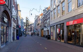 HAARLEM, NETHERLANDS - DECEMBER 21: A deserted shopping street is seen on December 21, 2021 in Haarlem, Netherlands. Due to the renewed lockdown, all shops other than grocery stores and drugstores are closed nationwide. Christmas shopping can be done through click and collect only. The catering industry is also closed. Some catering establishments have set up a collection points outside. (Photo by Helene Wiesenhaan/BSR Agency/Getty Images)