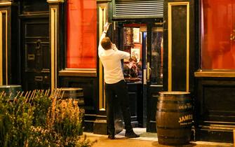 1237357054 Bar workers clear tables and chairs as a new 8pm closing time for pubs and restaurants in Ireland came into force this evening. Picture date: Monday December 20, 2021. See PA story IRISH Coronavirus. Photo credit should read: Damien Storan/PA Wire (Photo by Damien Storan/PA Images via Getty Images)