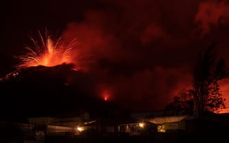TOPSHOT - The Cumbre Vieja volcano, pictured from El Paso, spews lava on the Canary island of La Palma, Spain on December 13, 2021. - The Cumbre Vieja volcano has been erupting since September 19, forcing more than 6,000 people out of their homes as the lava burnt its way across huge swathes of land on the western side of La Palma. (Photo by PIERRE-PHILIPPE MARCOU / AFP) (Photo by PIERRE-PHILIPPE MARCOU/AFP via Getty Images)