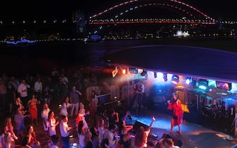 SYDNEY, AUSTRALIA - DECEMBER 31: People dance during New Year's Eve celebrations at the Sydney Opera House on December 31, 2021 in Sydney, Australia. New Year's Eve celebrations continue to be somewhat different as some COVID-19 restrictions remain in place due to the ongoing coronavirus pandemic. (Photo by Brook Mitchell/Getty Images)