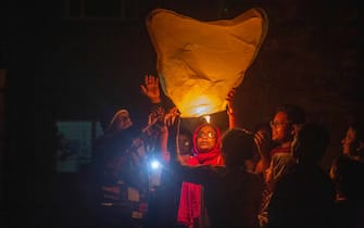 epa09661678 People light and release sky lanterns during New Year's celebrations in Dhaka, Bangladesh, 31 December 2021. Dhaka authority has issued special instructions for New Year celebration, banning open-air programs, parties and fireworks.  EPA/MONIRUL ALAM