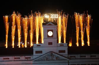 epa09661958 The bells of the clock tower of the Real Casa de Correos, located in Puerta del Sol, announce the New Year 2022 with fireworks, in Madrid, Spain, 31 December 2021.  EPA/Juan Carlos Hidalgo