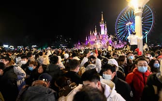 People wearing face masks attend a New Year's countdown at an amusement park in Beijing on January 1, 2022. (Photo by Jade GAO / AFP) (Photo by JADE GAO/AFP via Getty Images)