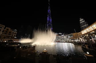 epa09661528 People gather near Burj Khalifa, the world's tallest building, prior to a fireworks display on New Year's Eve in Gulf emirates of Dubai, United Arab Emirates, 31 December 2021.  EPA/ALI HAIDER
