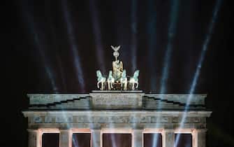 epa09662003 Illumination is seen in the sky over the Quadriga statue of the Brandenburg Gate on the occasion of the New Year's Eve TV broadcast production  Celebrate at the Gate  in Berlin, Germany, 01 January 2022. Due to the spreading of the Omicron variant in the ongoing Coronavirus pandemic, which causes the Covid-19 disease, Germany banned private New Year s Eve fireworks for New Year celebrations again. The Public TV show 'Celebrate at the Gate' takes place as a live broadcast without spectators being present.  EPA/CLEMENS BILAN