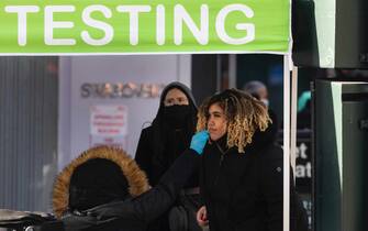 epa09666593 A person gets tested for COVID-19 at a testing tent on a sidewalk in the Midtown neighborhood of New York, New York, USA, 04 January 2022. The COVID-19 positivity rate in New York City is reportedly at 33%.  EPA/JUSTIN LANE