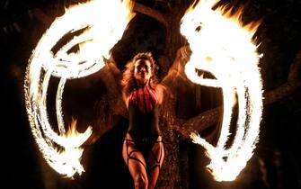 epa09500102 The artist Raquel Poti performs a dance with fire in Rio de Janeiro, Brazil, 30 September 2021 (issued 01 October 2021). Poti teaches fire dance in the open air and, after a long period of quarantine, assured Efe that this act represents the phoenix, which rises from the ashes with the advance of vaccination against covid-19.  EPA/Antonio Lacerda