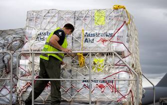 NUKU'ALOFA, TONGA - JANUARY 20: In this handout image provided by the Australian Defence Force, Australian Defence Force members load humanitarian aid supplies onto a Royal Australian Air Force C-17A Globemaster III aircraft at RAAF Base Amberley on January 20, 2022 in Nuku'alofa, Tonga. The undersea Hunga Tonga-Hunga Ha'apai volcano near Tonga erupted on Saturday 15 January, causing a subsequent tsunami in the nearby Tongan capital of Nuku'alofa and surrounding islands as well as triggering tsunami warnings across the Pacific region. (Photo by LACW Kate Czerny/Australian Defence Force via Getty Images)