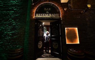 DUBLIN, IRELAND - DECEMBER 20: Head bar man Frank Shannon shuts the doors at the Merchant’s Arch bar on December 20, 2021 in Dublin, Ireland. The new rules, which last until January 30, require hospitality venues to shut nightly at 8pm, in an effort to curb the spread of Covid-19 and its highly contagious Omicron variant. (Photo by Charles McQuillan/Getty Images)