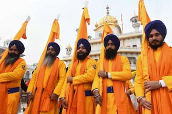 Sikh devotees, known as Panj Pyare, hold religious flags during a processionÂ on the eve ofÂ the birth anniversary of Sikh warrior Shaheed Baba Deep SinghÂ at the Golden Temple in Amritsar on January 26, 2022. (Photo by NARINDER NANU / AFP) (Photo by NARINDER NANU / AFP via Getty Images)