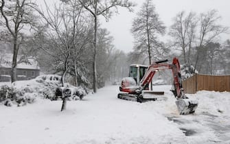 epa09717110 A homeowner uses a piece of construction equipment to start clearing his driveway as snow continues to fall in Orleans, Massachusetts, USA, 29 January 2022. A winter storm is expected to bring up to 40in (102cm) of snow to the east coast areas of Massachusetts, along with extreme high tides and flooding.  EPA/MATT CAMPBELL