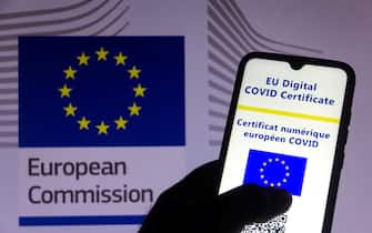 In this photo illustration the EU Digital COVID Certificate seen on a smartphone screen and the flag of the European Commission in the background. (Photo by Rafael Henrique / SOPA Images/Sipa USA)