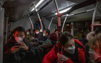 epa09730189 Journalists ride a crowded bus to the Olympic main media centre, which is part of the Olympic COVID-19 'bubble', during the Beijing 2022 Olympic Games in Beijing, China, 05 February 2022.  EPA/ROMAN PILIPEY