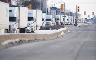 TOPSHOT - A line of trucks waits for the road to the Ambassador Bridge border crossing in Windsor, Ontario to reopen February 8, 2022, after protesters blocked the road Monday night. - The protestors supporting the Truckers Convoy in Ottawa blocked traffic in the Canada bound lanes since Monday evening. Approximately $323 million worth of goods cross the Windsor-Detroit border each day at the Ambassador Bridge making it North Americas busiest international border crossing. (Photo by Geoff Robins / AFP) (Photo by GEOFF ROBINS/AFP via Getty Images)