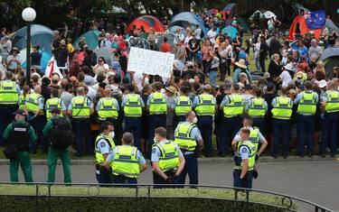 WELLINGTON, NEW ZEALAND - FEBRUARY 10: Police officers form a line in front of protesters at Parliament on February 10, 2022 in Wellington, New Zealand. Anti-vaccine and Covid-19 mandate protesters were broken up by police after three days of demonstrations outside Parliament. (Photo by Hagen Hopkins/Getty Images)