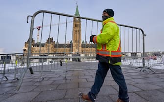 epa09741745 A worker move fence in front of parliament hill as truckers continue to protest the vaccine mandates in in downtown Ottawa, Ontario, Canada, 09 February 2022. Since 29 January 2022, truckers are protesting against the mandate by the Canadian government that truckers be vaccinated against COVID-19 to return to Canada, and was joined by other opponents of the Canadian Prime Minister. A state of emergency was declared in the city of Ottawa on 06 February 2022 and policemen from Ottawa city, Ontario, and the Federal Royal Canadian Mounted Police (RCMP) are deployed.  EPA/ANDRE PICHETTE