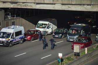 epa09749360 French police forces stand at a checkpoint on the Paris ring road to prevent members of the 'Freedom Convoy' from entering Paris, France, 12 February 2022. Paris police have prohibited the convoy, as announced by the capital s prefect on 10 February. A series of convoy demonstrations has been taking place in France to call for the lifting of all Covid-19-related restrictions and mandates, in light of the ongoing protest in Canada, where truck drivers have been rallying against the government-imposed mandatory Covid-19 vaccine to enter the country.  EPA/CHRISTOPHE PETIT TESSON