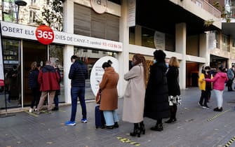 epa09657135 A group of people line up to get themselves tested (PCR or antigen method) for Covid-19 in front of a clinical analisys laboratory in Barcelona, north-eastern Spain, 26 December 2021. As the omicron variant hit Spain, the government concluded this week that masks outdoors were the solution.  EPA/Enric Fontcuberta